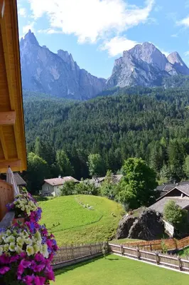 a view of a mountain range from a balcony with flowers at Haus Bernard in Siusi