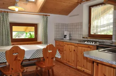 a kitchen with a table and two chairs in it at Planatscherhof in Barbiano