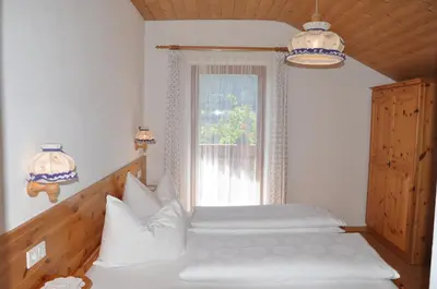 a bedroom with two white beds and a window at Planatscherhof in Barbiano