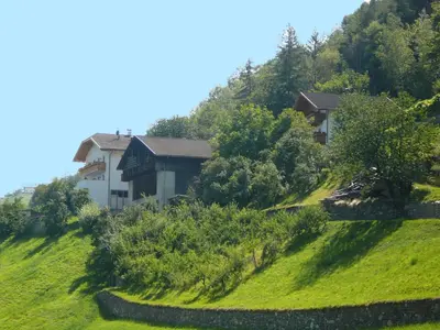 a house on the side of a green hill at Planatscherhof in Barbiano