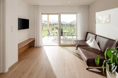 a living room with a couch and a table at Prälatenhof Wine & Apartments in Caldaro