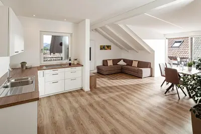 a kitchen and living room with a couch and a table at Prälatenhof Wine & Apartments in Caldaro