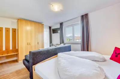 a bedroom with a white bed and a table at Garni Schmiedhof in Naturno