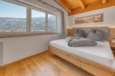 a bedroom with a bed and a couch and a window at Garni Schmiedhof in Naturno