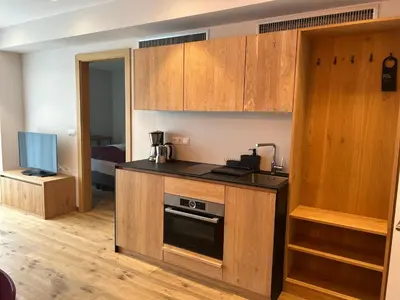 a kitchen with wooden cabinets and a stove at Dining & Living Alpenrose in Bressanone