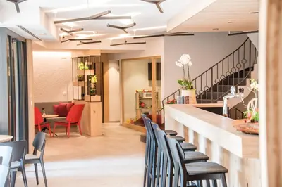 a bar in a restaurant with chairs and tables at Dining & Living Alpenrose in Bressanone