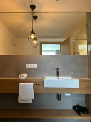 a bathroom with a sink and a mirror at Dining & Living Alpenrose in Bressanone