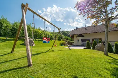a swing set in a yard with a house at Pension Etschblick B&B in Frangarto