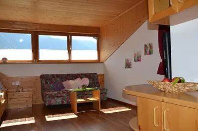 a living room with a chair and a table at Burggräflerhof in Lana