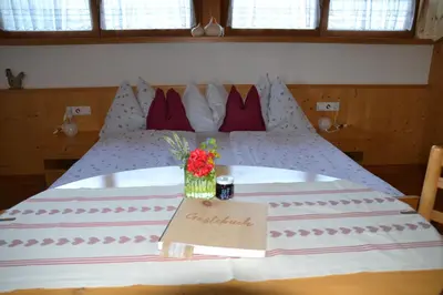 a large bed with a table with flowers on it at Burggräflerhof in Lana