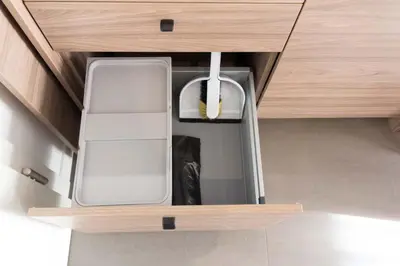 a drawer in a wooden cabinet with a white box at Apartments Sissi & Franz in Merano