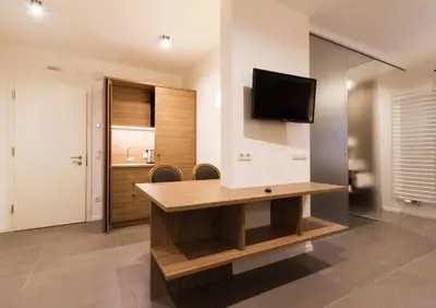 a room with a desk with a television on a wall at Apartments Sissi & Franz in Merano