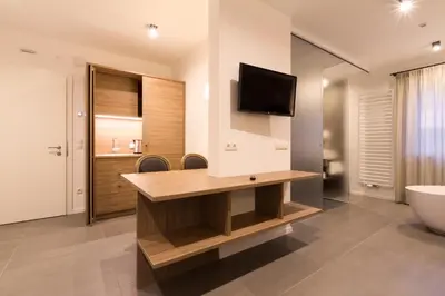 a bathroom with a sink and a tv on a wall at Apartments Sissi & Franz in Merano