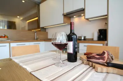 a bottle of wine and a glass on a table at Apartments Mujnei in Santa Cristina in Val Gardena