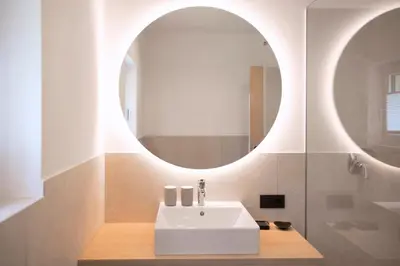 a bathroom with a white sink and a mirror at FELDHOF - Agri-apartment-suites in Termeno