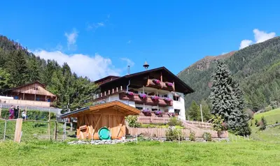 a house with flowers on the balcony of it at Alpegger in Terento