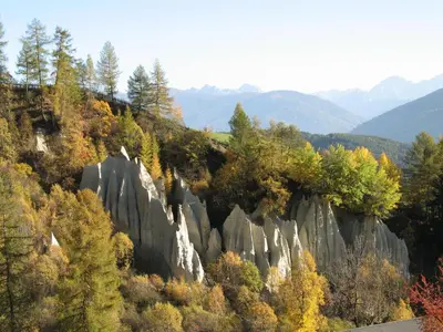 a mountain with trees and rocks and a road at Alpegger in Terento