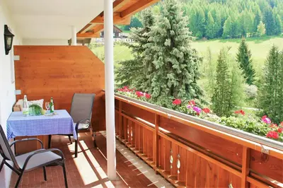 a patio with a table and chairs on a balcony at Alpegger in Terento