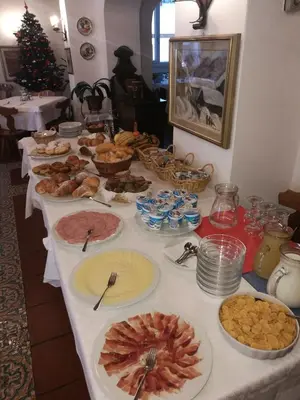 a long table with many plates of food on it at Hotel Fiames in Cortina dʼAmpezzo