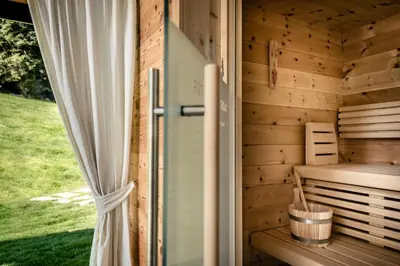 a wooden sauna with a door and a window at Pradel Dolomites in San Martino in Badia