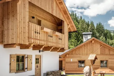 a wooden house with a balcony on top of it at Pradel Dolomites in San Martino in Badia