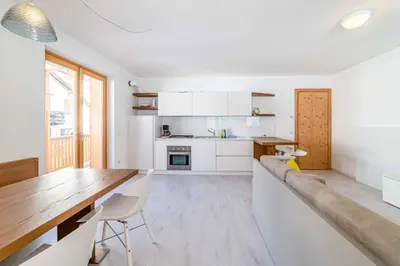a kitchen with a long table and white cabinets at Olivia Home in Caprile