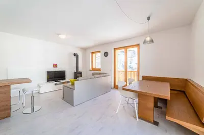 a kitchen and living room with a table and chairs at Olivia Home in Caprile