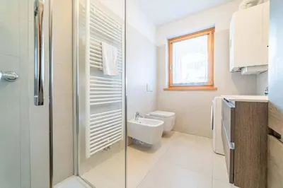 a bathroom with a shower and a toilet and a sink at Olivia Home in Caprile