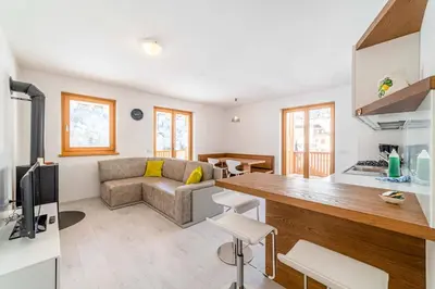 a kitchen and living room with a couch and a table at Olivia Home in Caprile