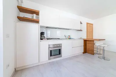 a white kitchen with white cabinets and a counter at Olivia Home in Caprile