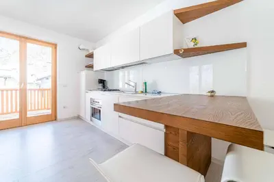 a kitchen with white cabinets and a wooden counter top at Olivia Home in Caprile