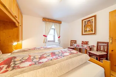 a bedroom with a large bed and a window at Ospitalità Diffusa Laste Dolomites - Cèsa Murer in Pallua