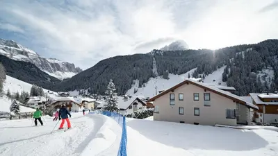 a group of people skiing down a snow covered slope at Villa David Dolomites in Selva di Val Gardena