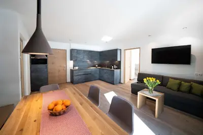 a living room with a couch and a table with oranges on it at Villa David Dolomites in Selva di Val Gardena