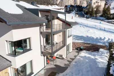 an aerial view of a building with a ski slope at Villa David Dolomites in Selva di Val Gardena