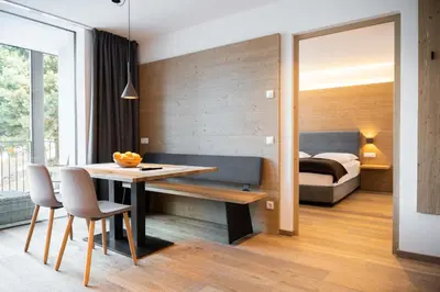a bedroom with a bed and a table and chairs at Villa David Dolomites in Selva di Val Gardena