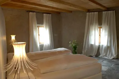 a bedroom with two beds and a table with a lamp at Grottnerhof in Fiè