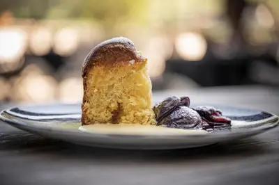 a piece of cake on a plate with cherries at Grottnerhof in Fiè