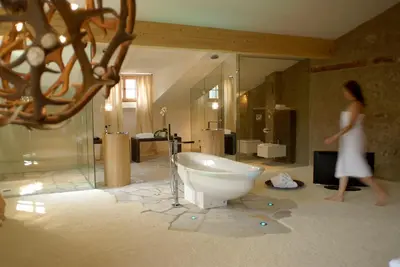 a woman walking in a bathroom with a bath tub at Grottnerhof in Fiè
