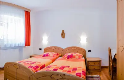 a bedroom with a bed and two pillows on it at Pramulin in Selva di Val Gardena