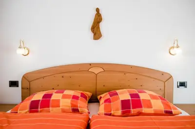 a bed with two pillows in a bedroom at Pramulin in Selva di Val Gardena