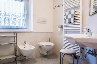 a bathroom with a toilet and a sink at Pramulin in Selva di Val Gardena