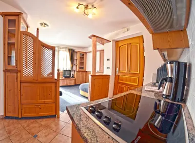 a kitchen with wooden cabinets and a counter top at Hammele Appartements in Schenna