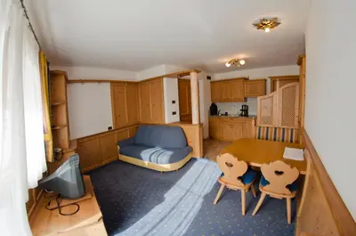 a small room with a table and a kitchen at Hammele Appartements in Schenna
