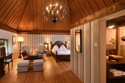 a living room with a bed and a chandelier at Ansitz Pünthof in Lagundo