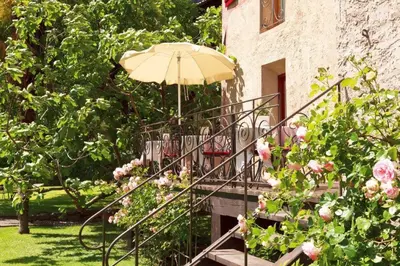 a staircase with an umbrella and some flowers at Ansitz Pünthof in Lagundo