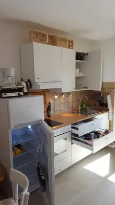 a kitchen with white cabinets with an open refrigerator at SonnenApartment in Lana
