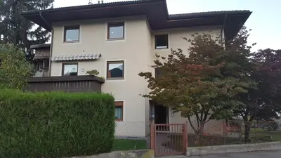 a white house with a fence in front of it at SonnenApartment in Lana