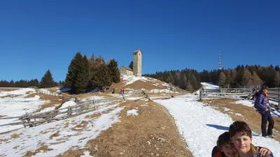 a group of people sitting on a snow covered hill at SonnenApartment in Lana