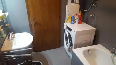 a bathroom with a washing machine and a sink at SonnenApartment in Lana
